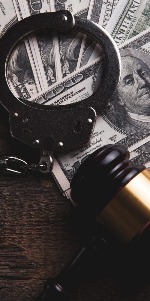 judge's hammer, handcuffs and money on the table