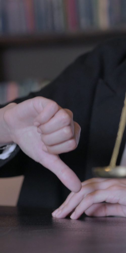 Close Up of Thumbs Down by Female Judge in Court