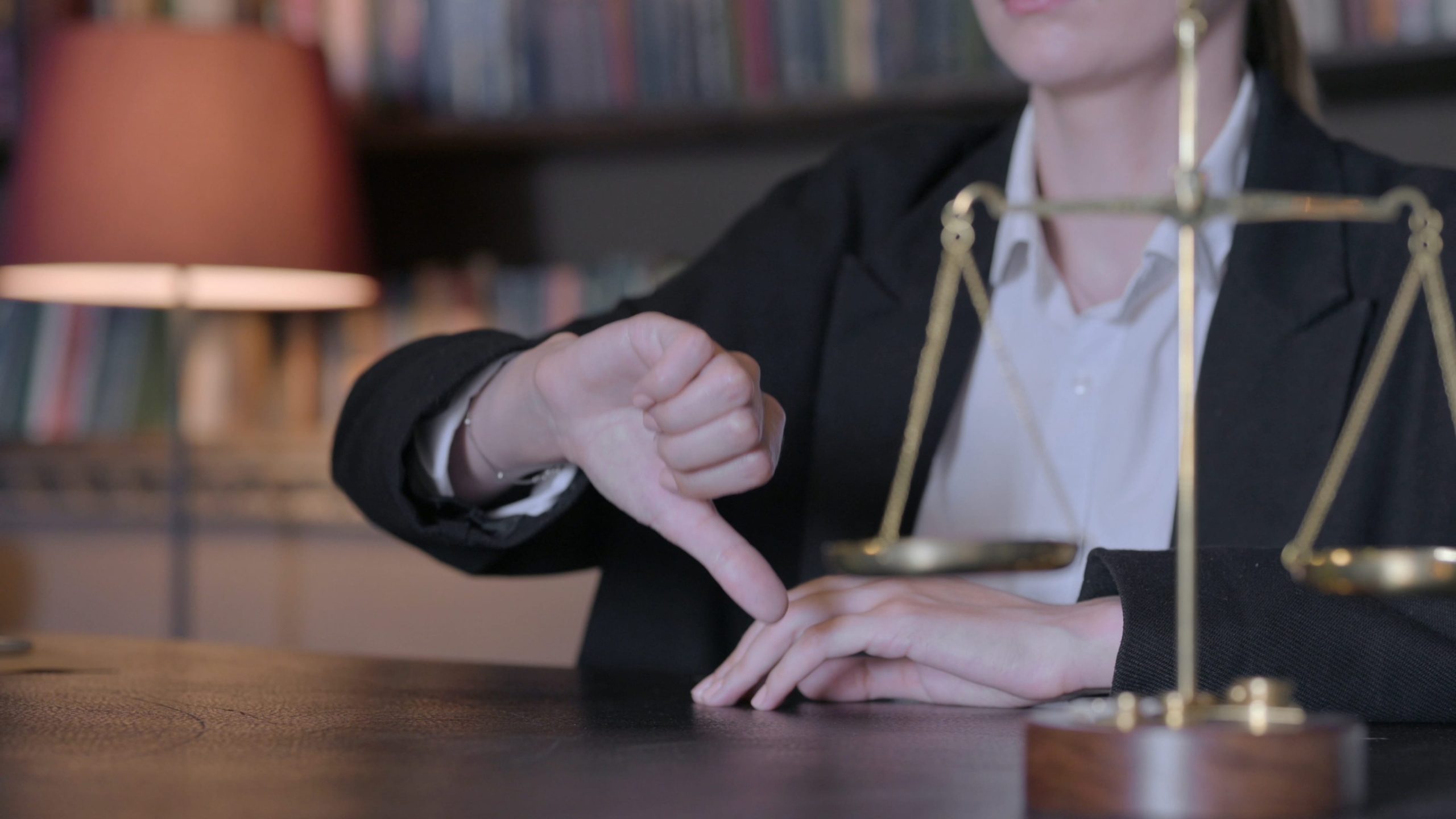 Close Up of Thumbs Down by Female Judge in Court