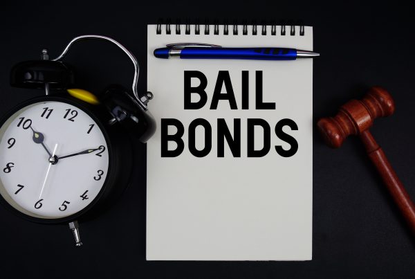 Bail Bonds text written on notepad with gavel and alarm clock on black background